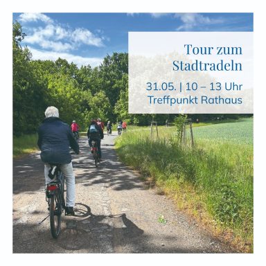 Radfahrer auf einem Weg, umgeben von Bäumen, mit Info zur Stadtradel-Tour.