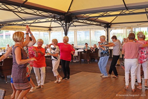 Tanzende Senioren in einem festlichen Restaurantambiente.